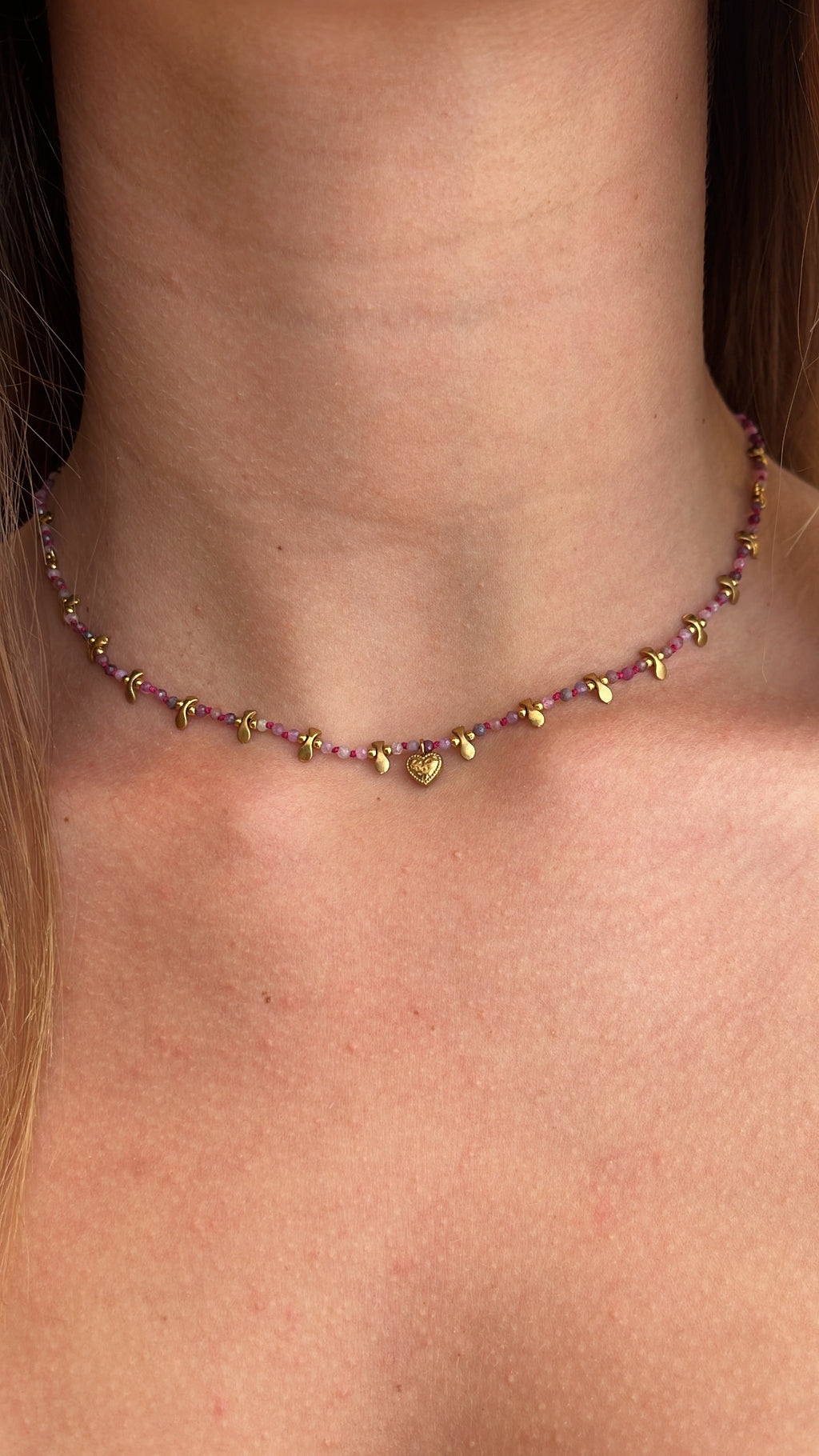 Collier orné de petites perles aux nuances rosé fuschia et rose pâle avec des pampilles en acier inoxydable doré 