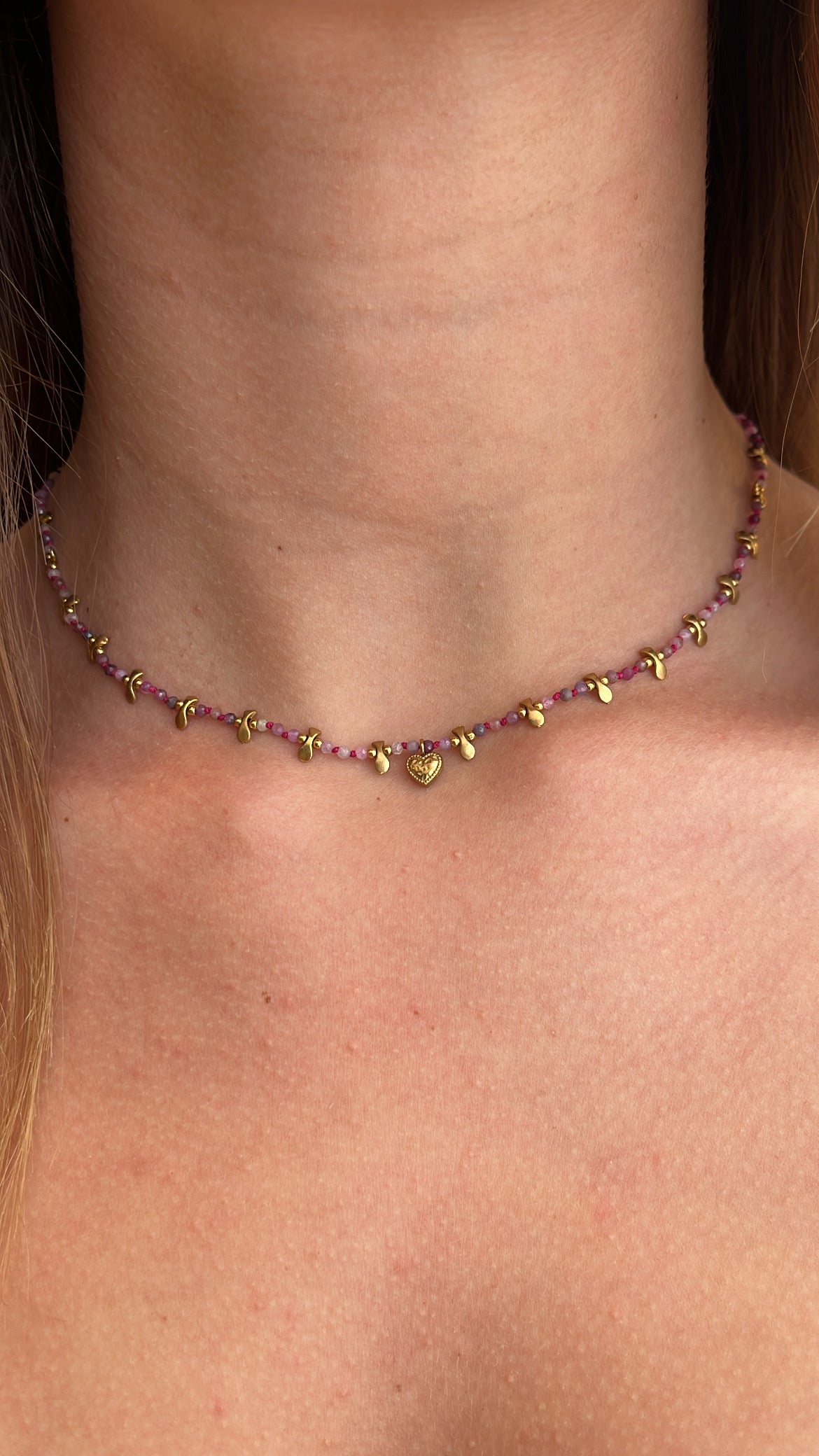 Collier orné de petites perles aux nuances rosé fuschia et rose pâle avec des pampilles en acier inoxydable doré 