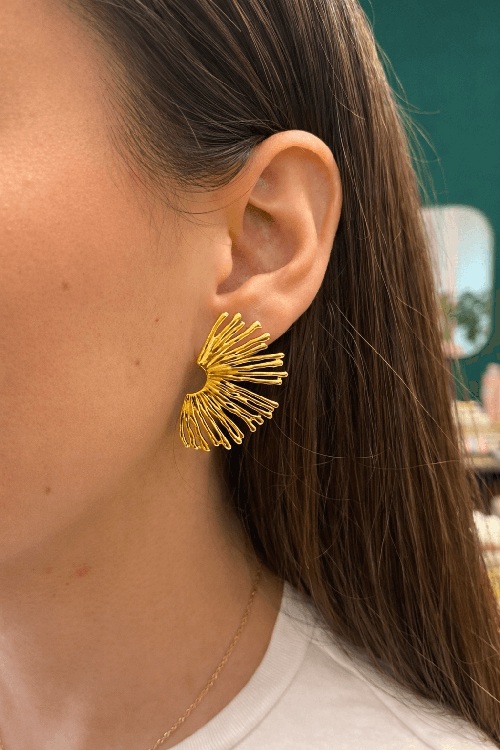 Femme portant une boucle d’oreille, en forme de demi soleil, en acier inoxydable doré