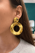 Femme portant une paire de boucles d’oreilles ronde pendante, en acier inoxydable doré 