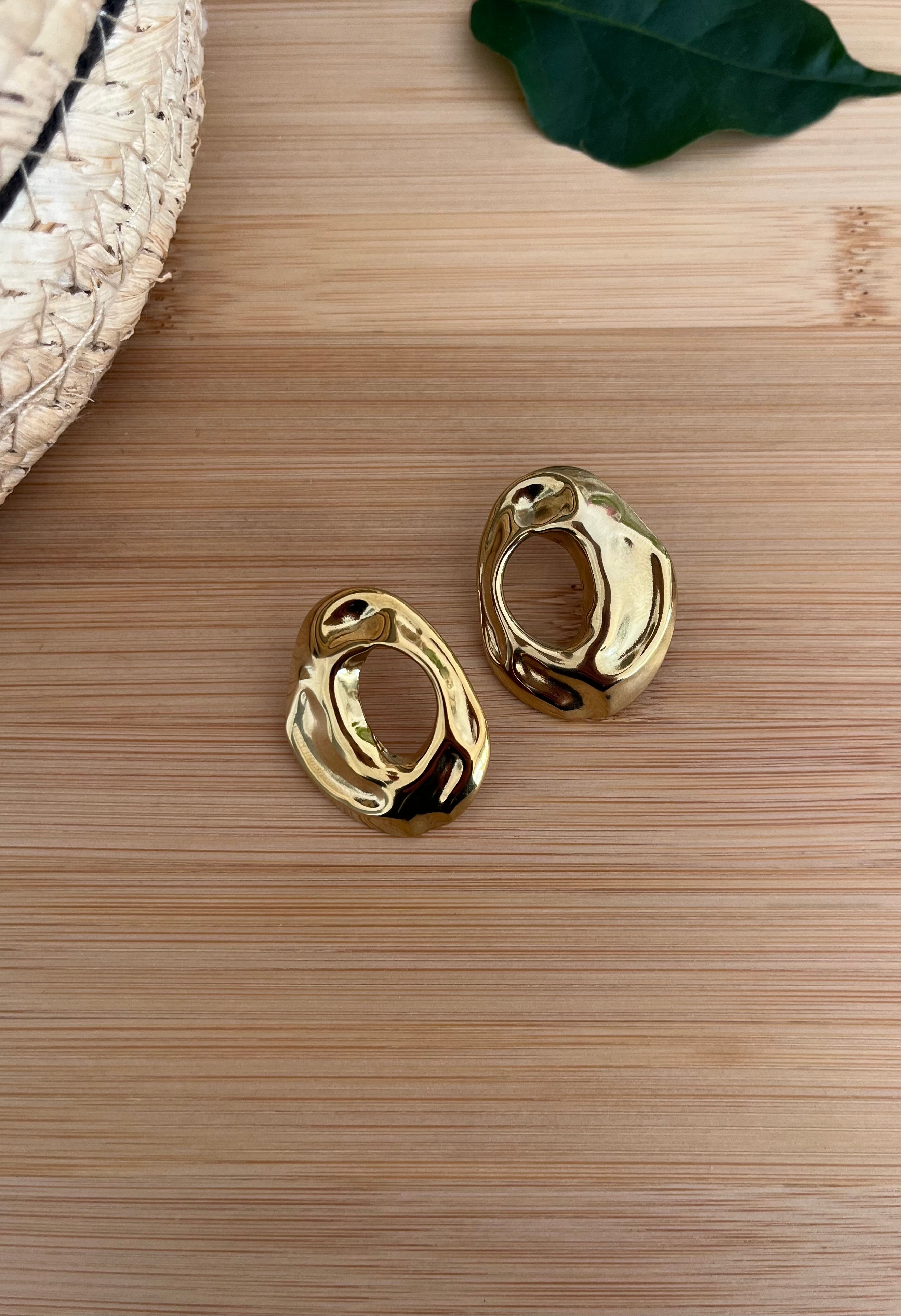 Paire de boucles d’oreilles en acier inoxydable doré, avec des parties en relief et un cercle que milieu 
