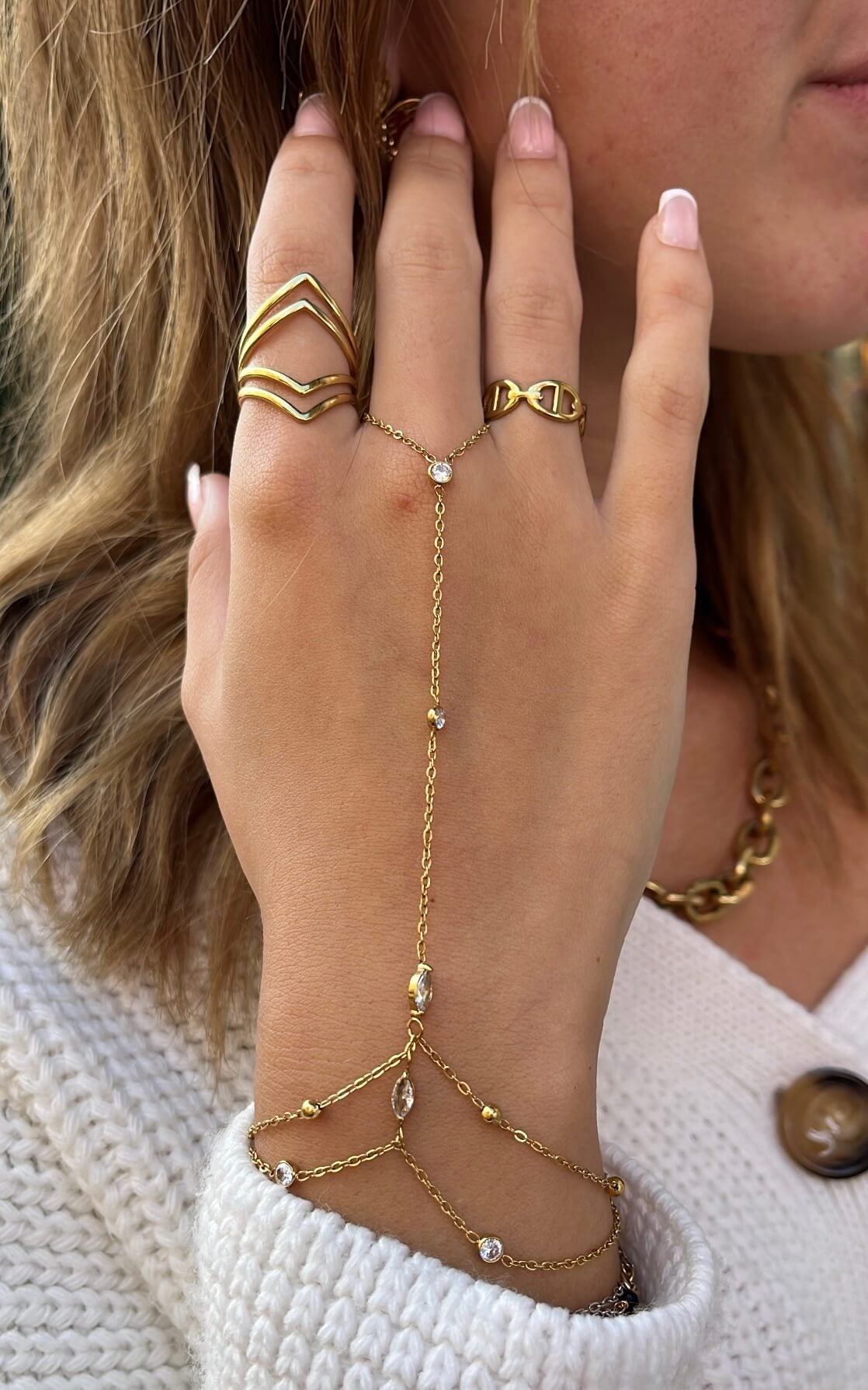 Main d’une femme portant un bracelet de main en acier inoxydable doré