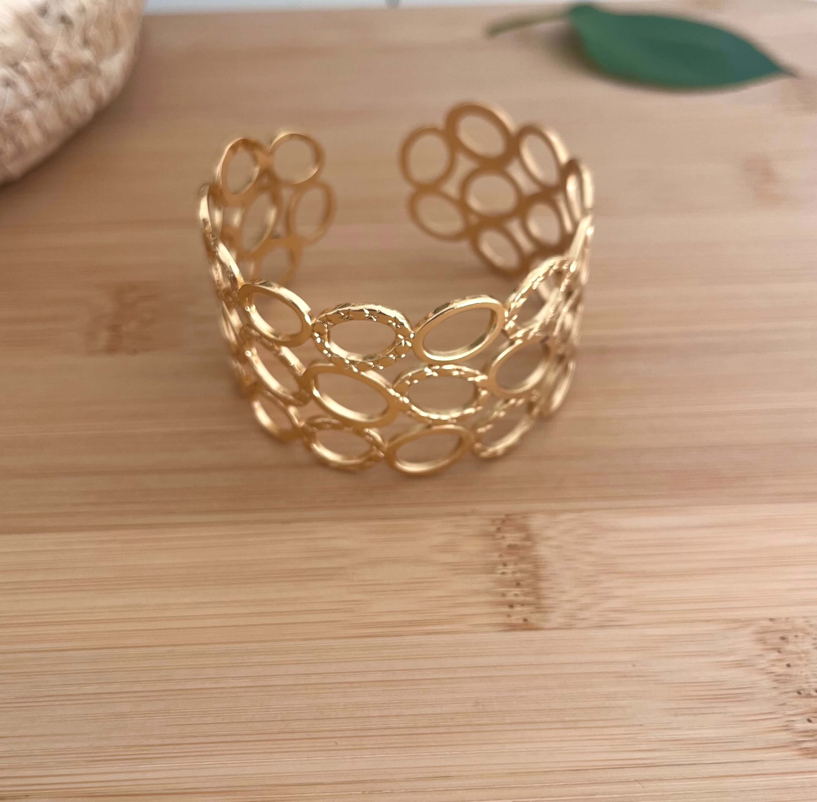 Bracelet manchette avec plein de trous ajourés, dont certains martelé, en acier inoxydable doré 