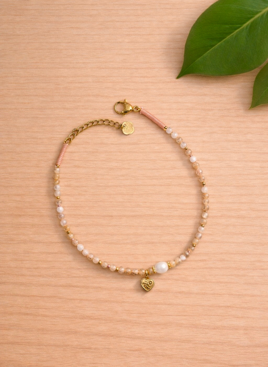 Bracelet en petite pierres roses, avec une perle blanche et un coeur en acier inoxydable doré