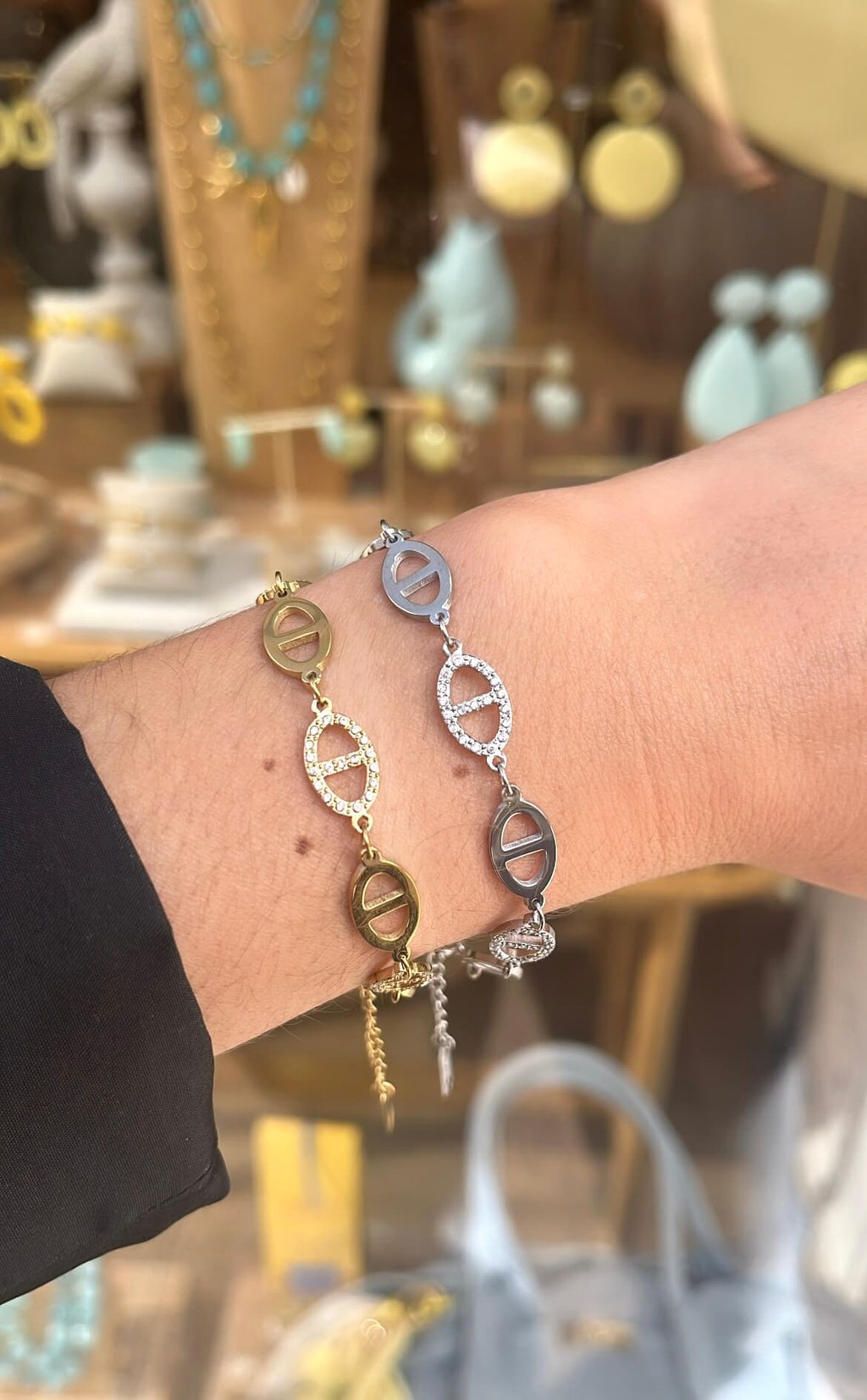 Poignet d’une femme portant deux bracelets en maille marine dont un doré et un en argenté