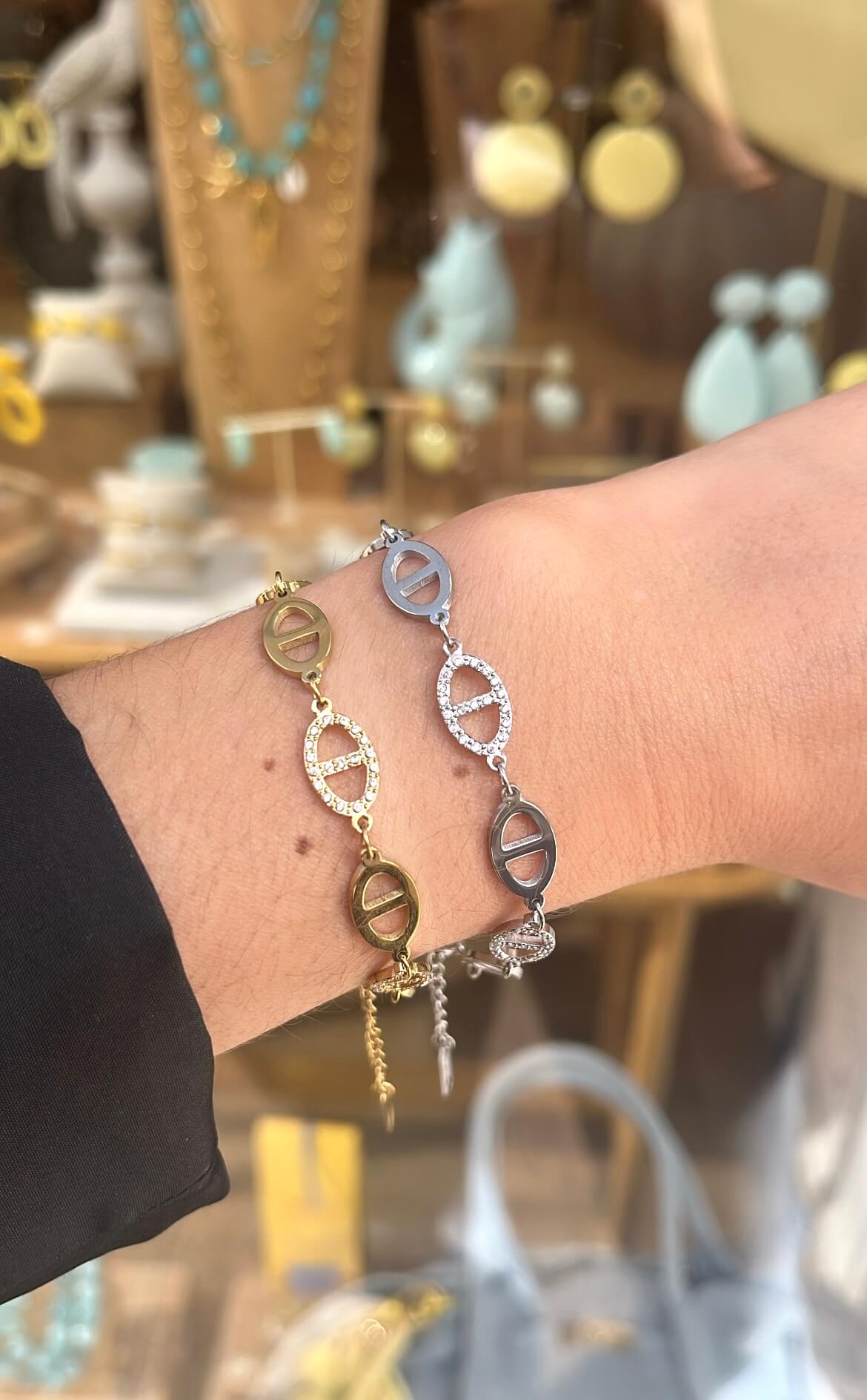 Poignet d’une femme portant deux bracelets en maille marine dont un doré et un en argenté