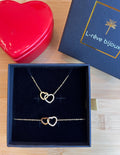 Coffret cadeau comprenant un collier et un bracelet doré avec 2 coeurs qui s’entremêlent