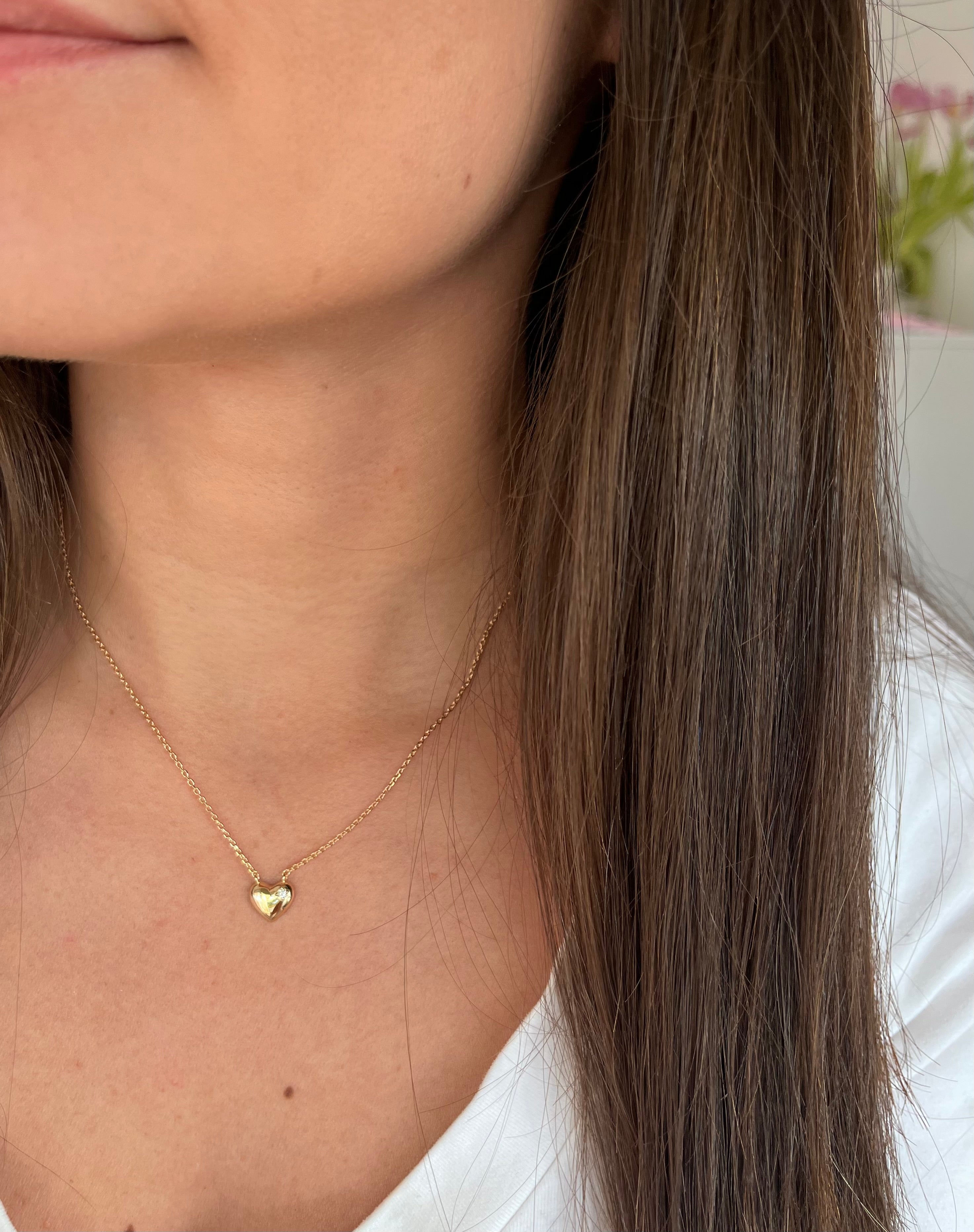 Cou d une femme portant un collier avec un petit coeur en plaqué or