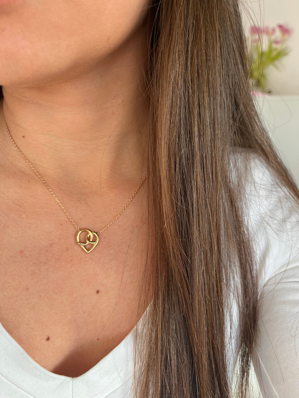 Femme portant un collier coeur en plaqué or 