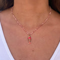 Cou d’une femme portant un collier avec des petites perles rose et un poisson en pendentif rose 