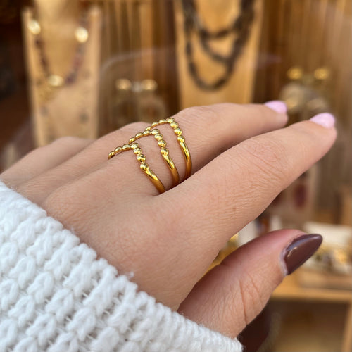 Main portant une bague en acier inoxydable doré vue de près 