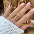Main portant une bague en acier inoxydable doré, que a 3 traits avec des petites boules sur le dessus 