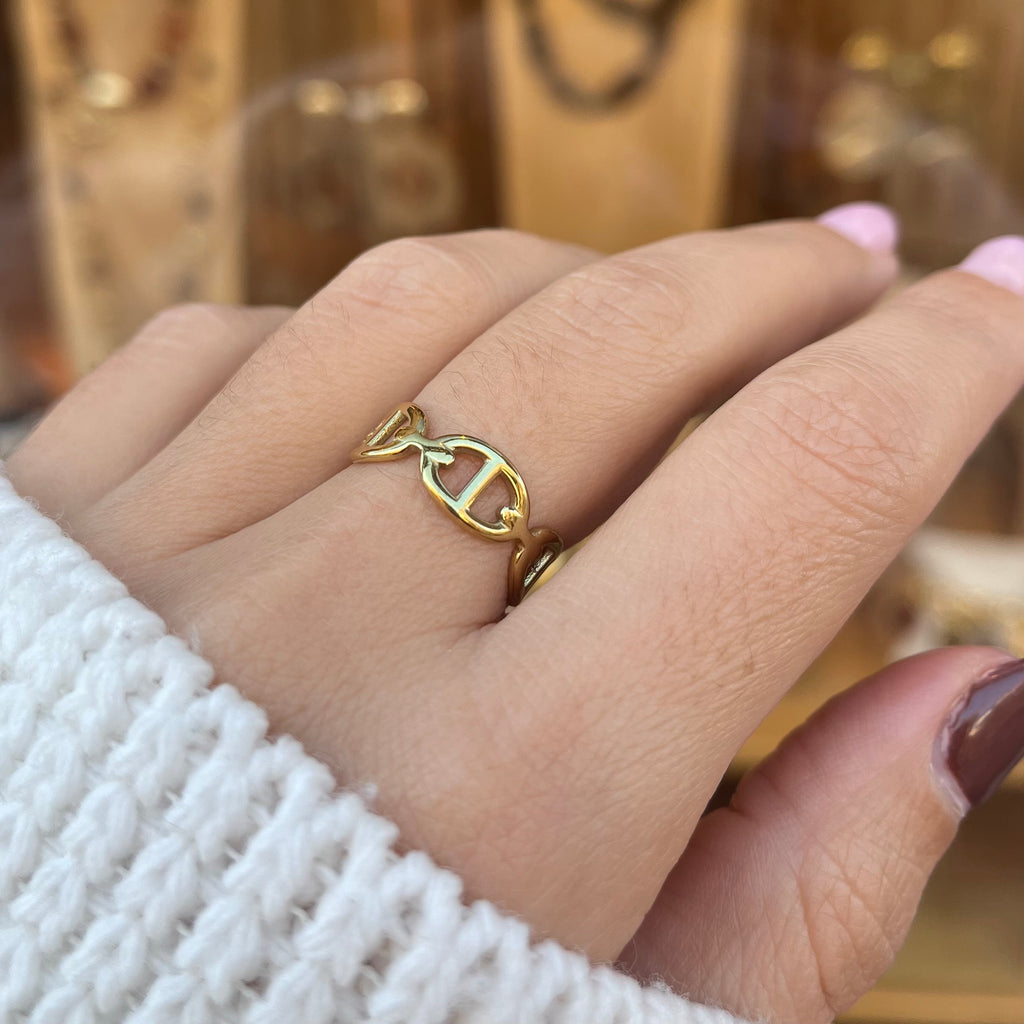 Main de femme portant une bague en maille marine, réglable en acier inoxydable doré