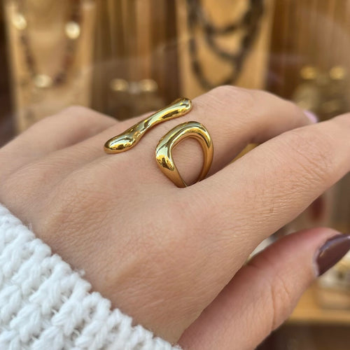 Bague en acier inoxydable doré, sur une main vue de près 