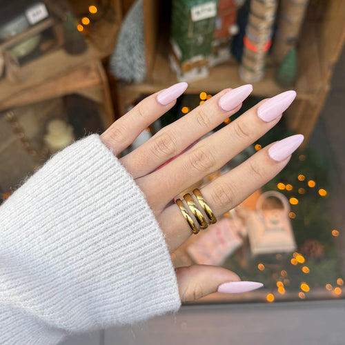 Main de femme portant une bague en acier inoxydable doré avec 3 rayures 