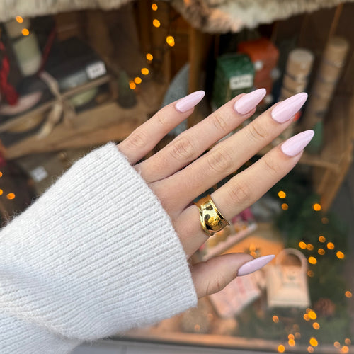 Main de femme portant une bague réglable en acier inoxydable doré avec des courbes