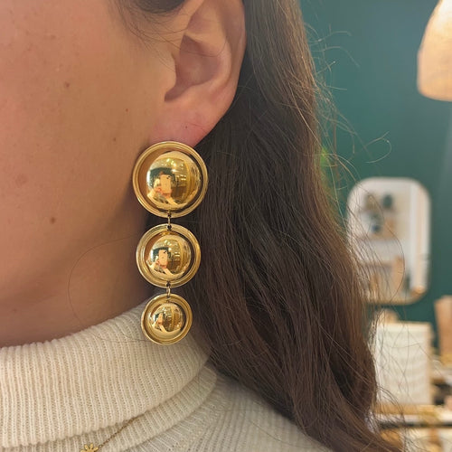 Boucles d’oreilles pendantes avec 3 ronds, résistant à l’eau, portée par une femme