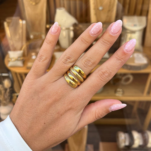 Main d une femme portant une bague en acier inoxydable doré avec 4 rangs 