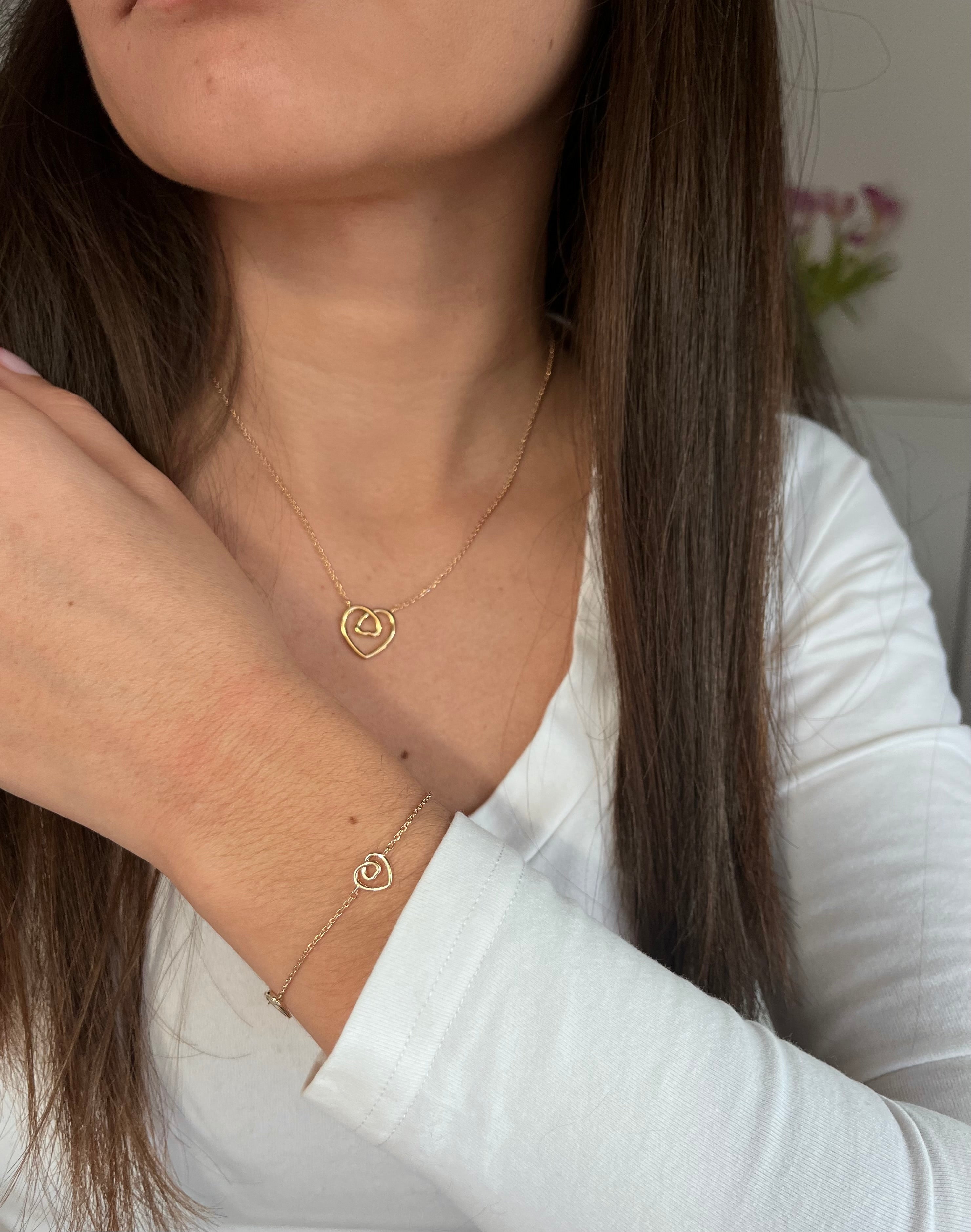 Femme portant une parure de bijoux avec collier en bracelet coeur en plaqué or 