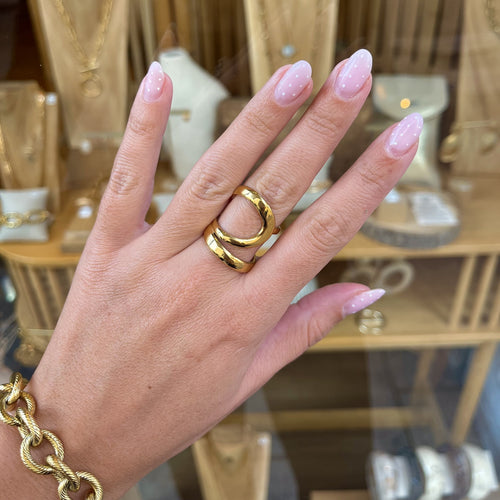 Main d’une femme portant une bague en acier inoxydable doré de chez L rêve bijoux