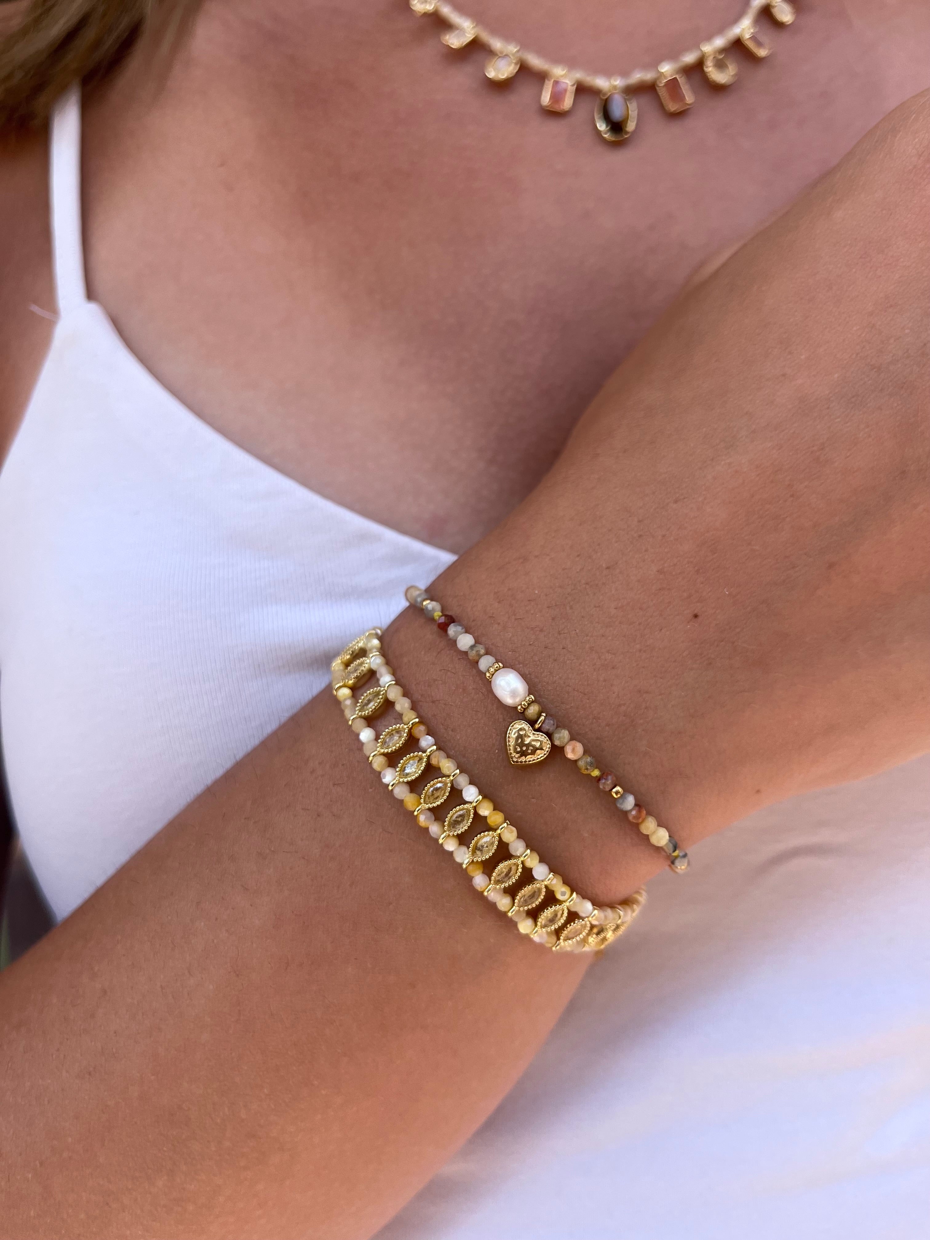 poignet d'une femme portant un duo de bracelet en pierres naturelles aux nuances de jaune 
