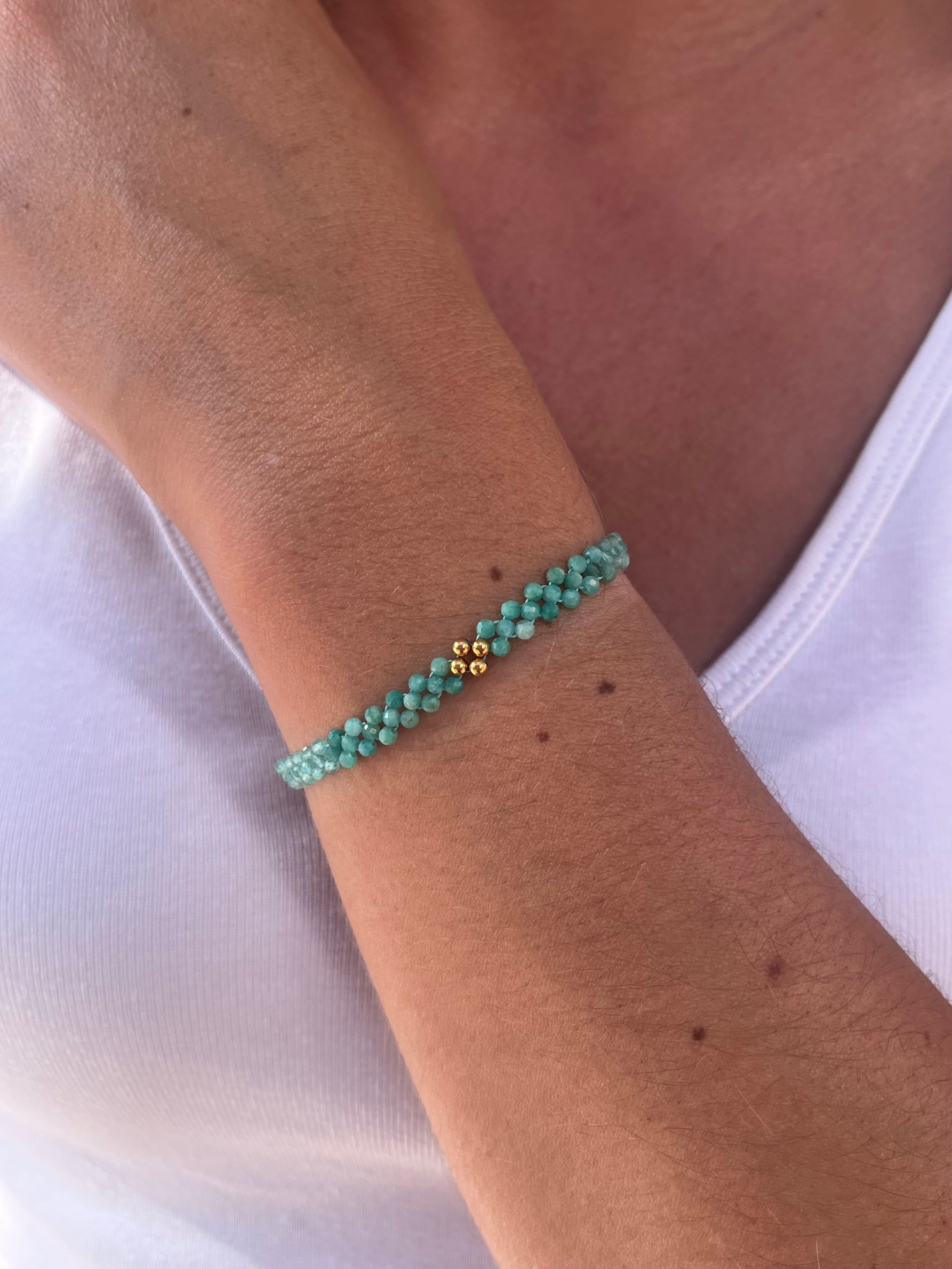 poignet de femme portant un bracelet avec des perles de couleurs bleue turquoise