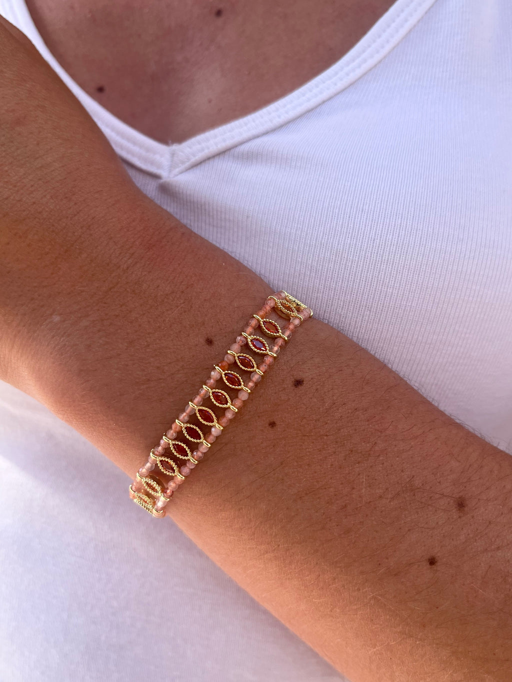 poignet portant un bracelet avec des pierres naturelles de cornaline