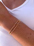 poignet portant un bracelet avec des pierres naturelles de cornaline