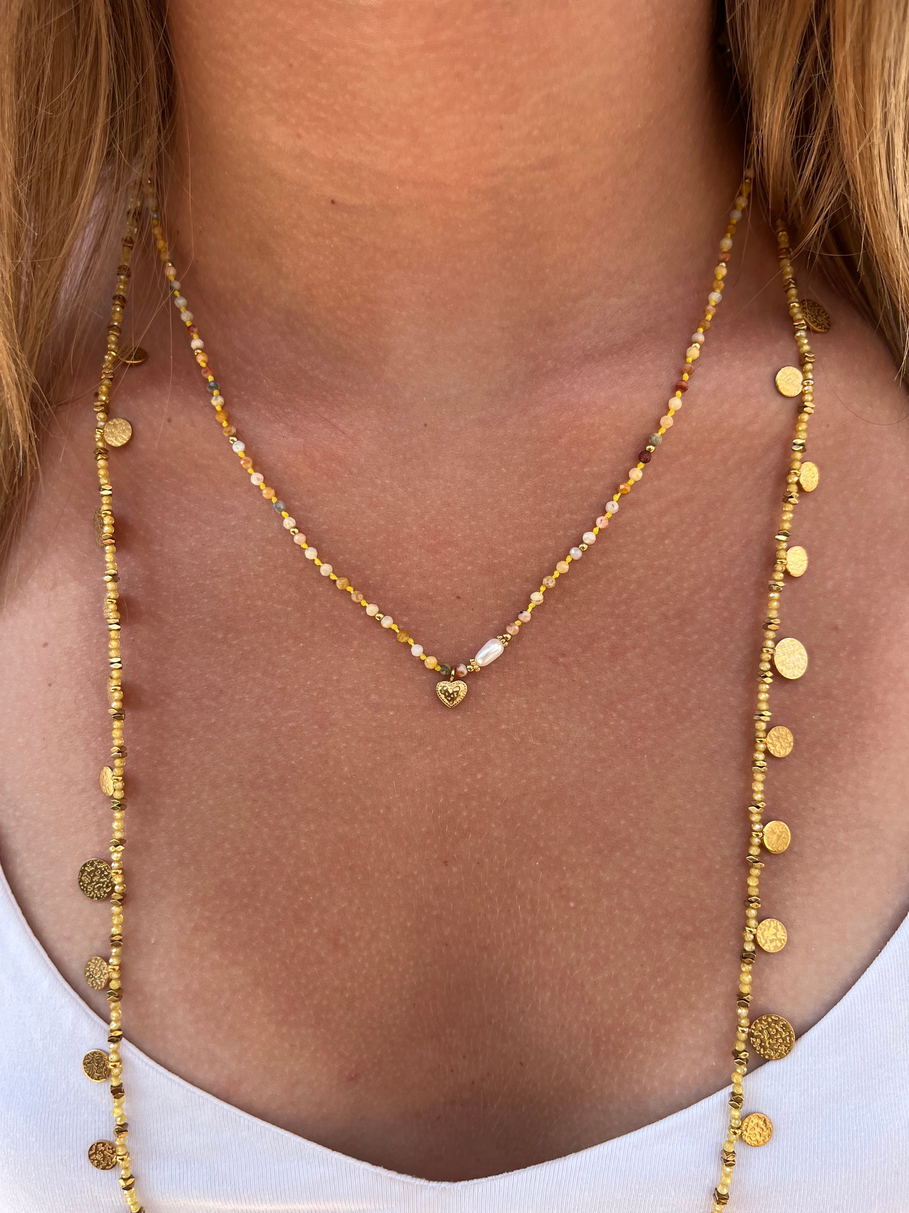 cou d'une femme portant un collier et un sautoir en pierre naturelles jaunes