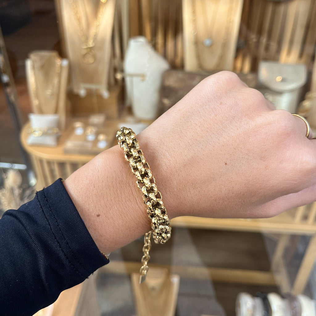 Poignet femme portant un bracelet maille en acier inoxydable doré