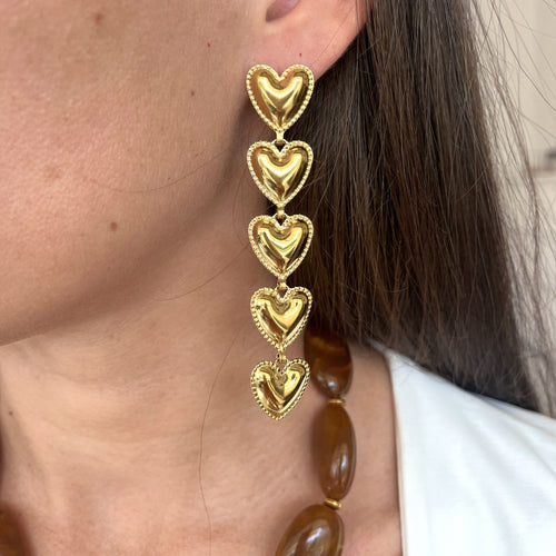 Paire de boucles d oreilles pendantes coeur portée par une femme 