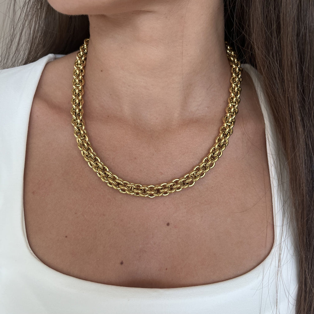 Cou d’une femme portant un collier en maille torsadée, en acier inoxydable doré